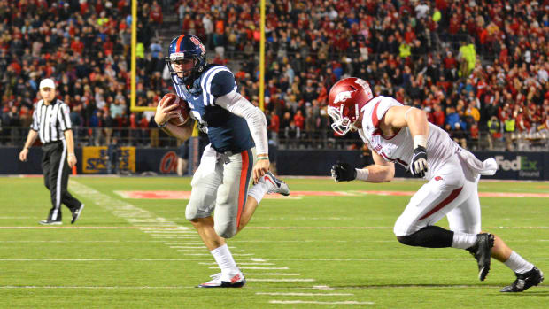 Nov 7, 2015; Oxford, MS, USA; Mississippi Rebels quarterback Chad Kelly (10) carries the ball past Arkansas Razorbacks linebacker Brooks Ellis (51) to score a touchdown in overtime at Vaught-Hemingway Stadium. The Razorbacks won 53-52.